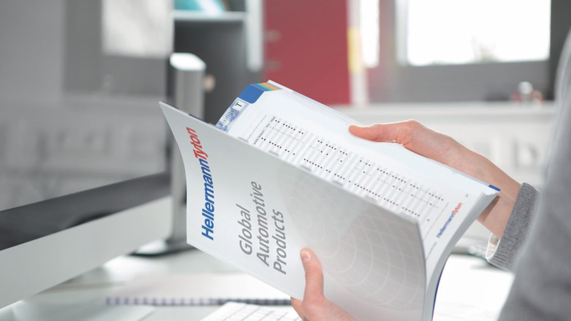 Man holding printed automotive catalogue in his hands